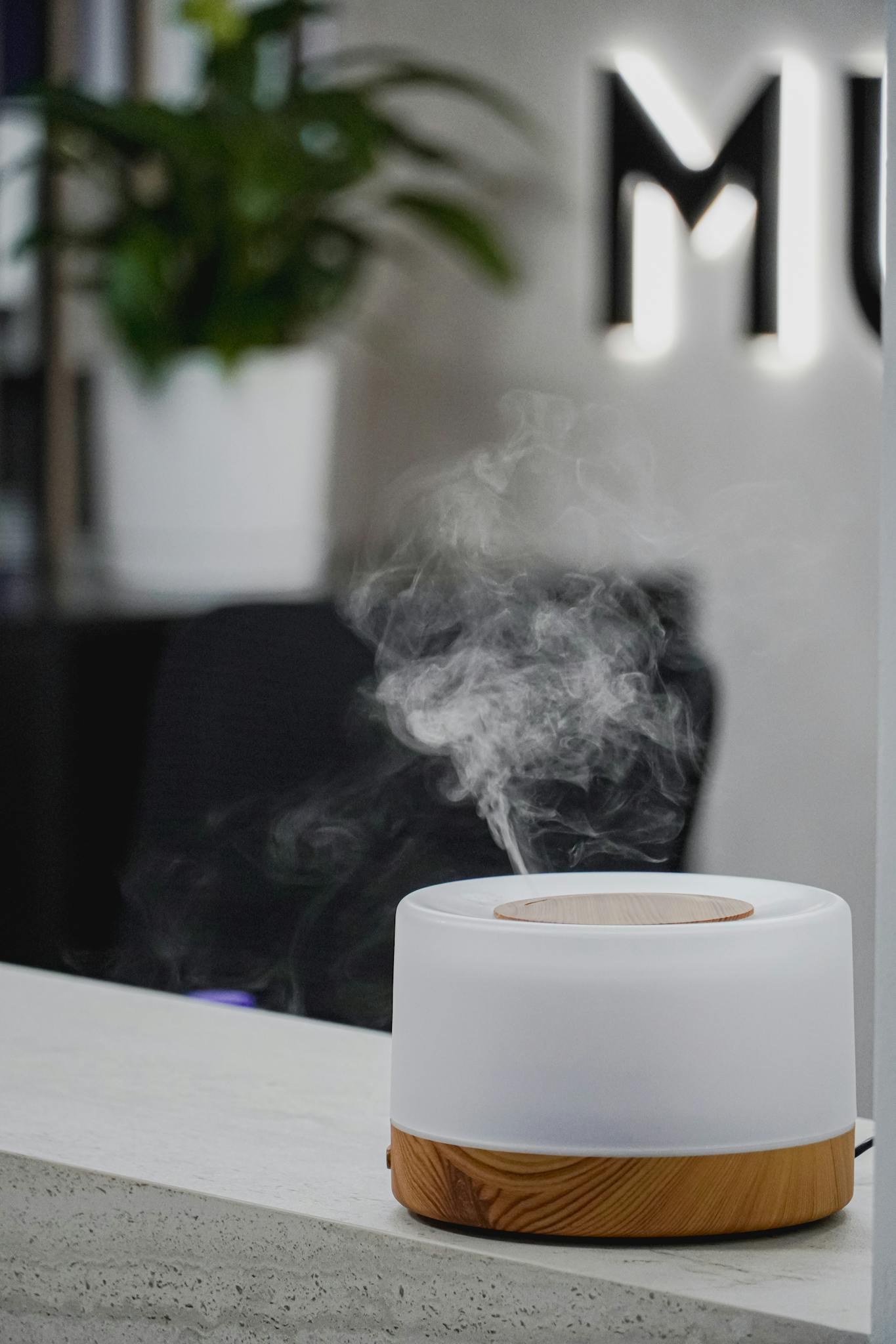 A white mist diffuser with a wooden table